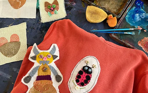 Sewing and applique projects on a red jumper