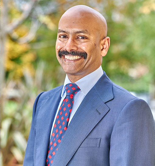 Board member Suresh Ariaratnam smiling to camera in outdoor headshot