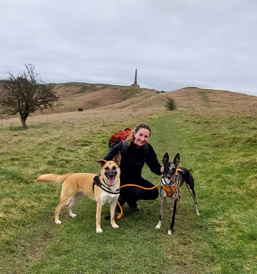 Penny Bullion-Peters on a hill with two dogs