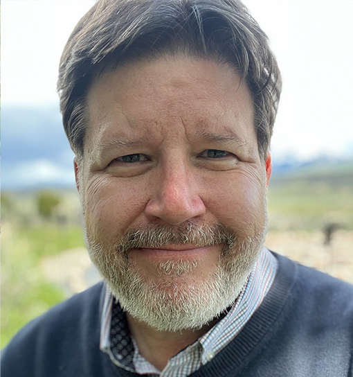 Dr Dan Wuori smiling to camera in an outdoor setting