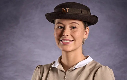 A Norland Nanny student in her formal uniform smiling