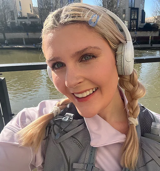 A female stood beside the river in Bath, UK wearing running clothes